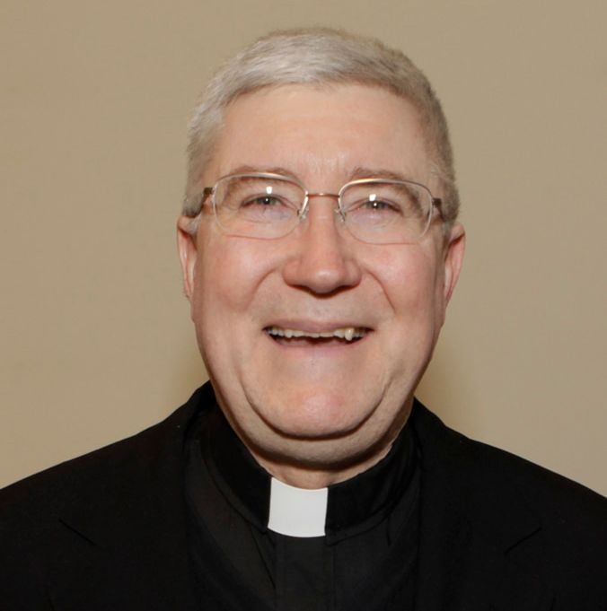 Catholic priest smiling at community services event.