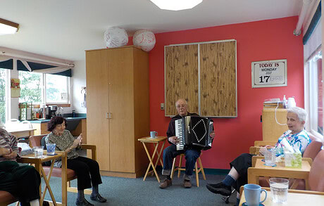 Senior residents enjoying music therapy session at Catholic Community Services center.